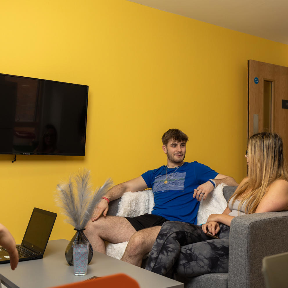 Male and female students sitting on sofa