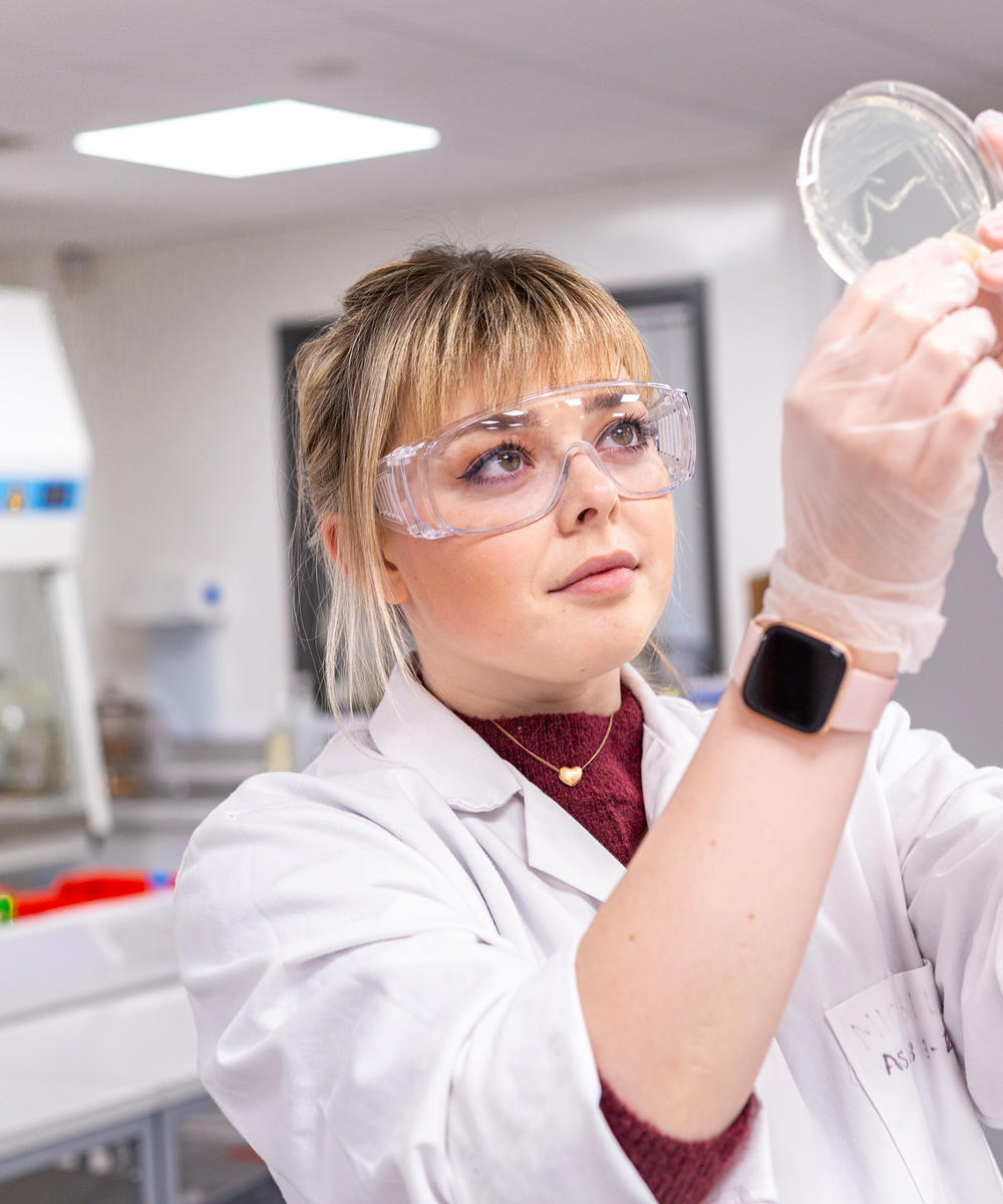 Female Student In Lab With Microbiology Plate