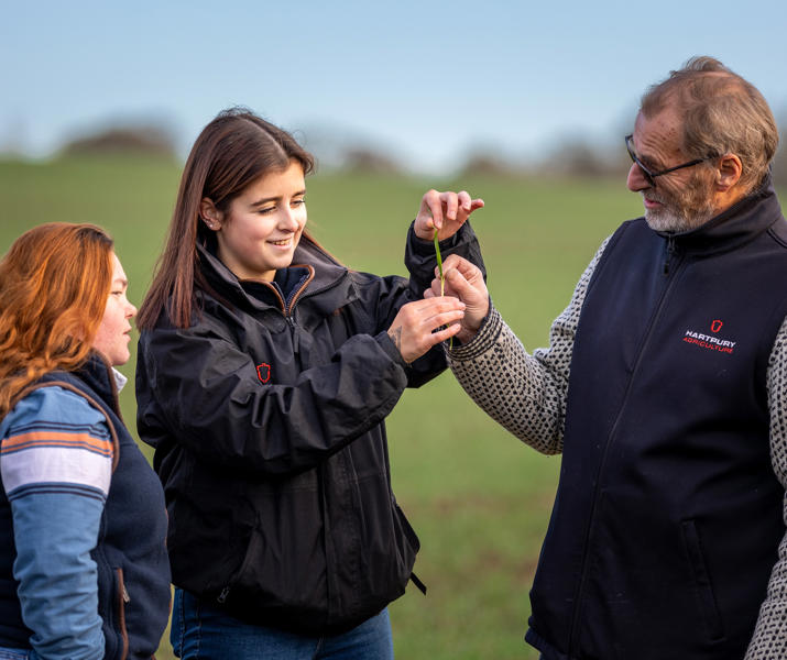 Two Female Students And Lecturer Checking Crop Health