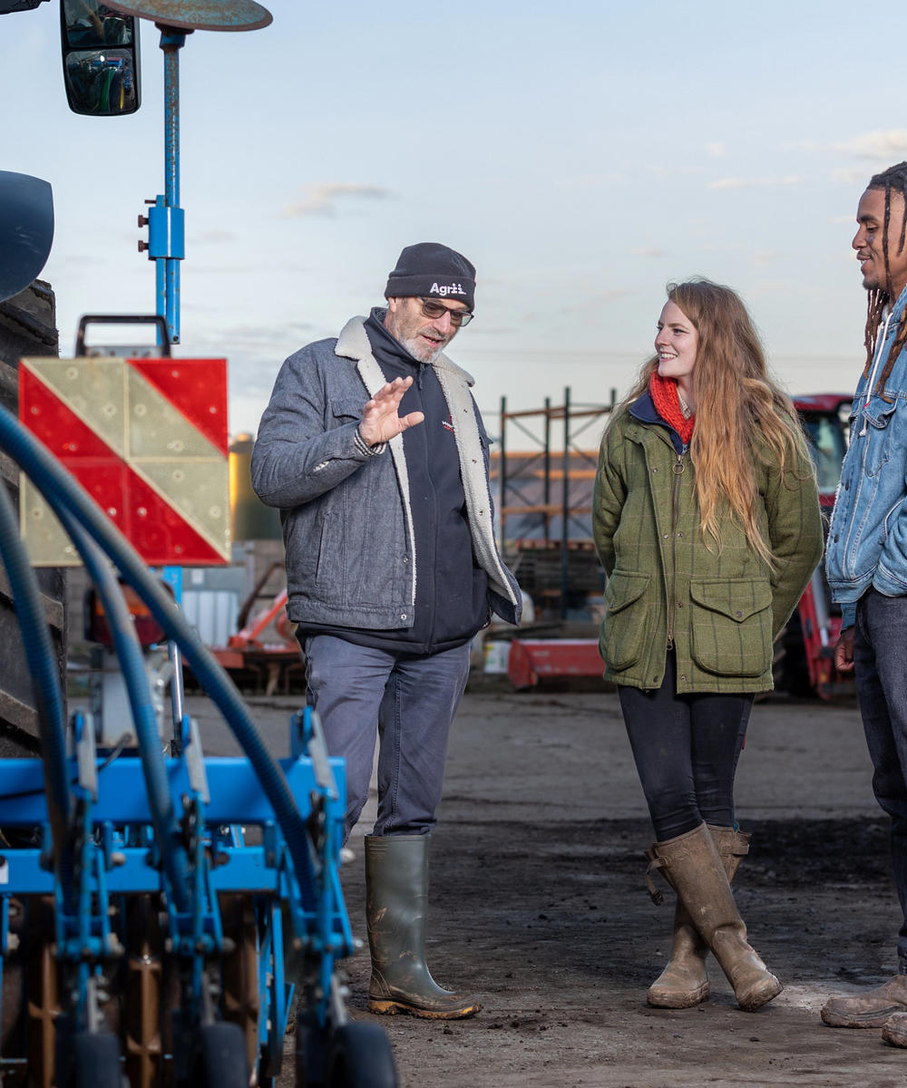 Students And Lecturer Looking At Farm Machinery